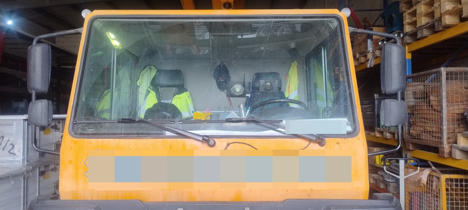 Defekte Verglasung an der Kabine einer Baumaschine vor dem Austausch